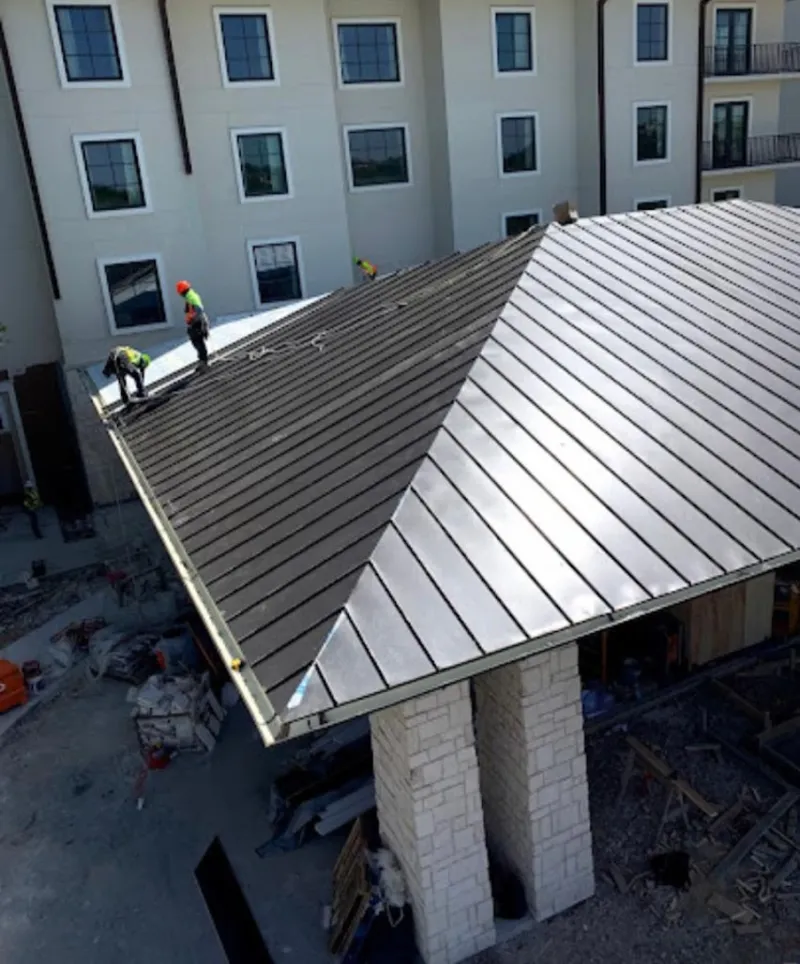 Crew installing standing seam metal roof panels on a commercial project in Coraopolis